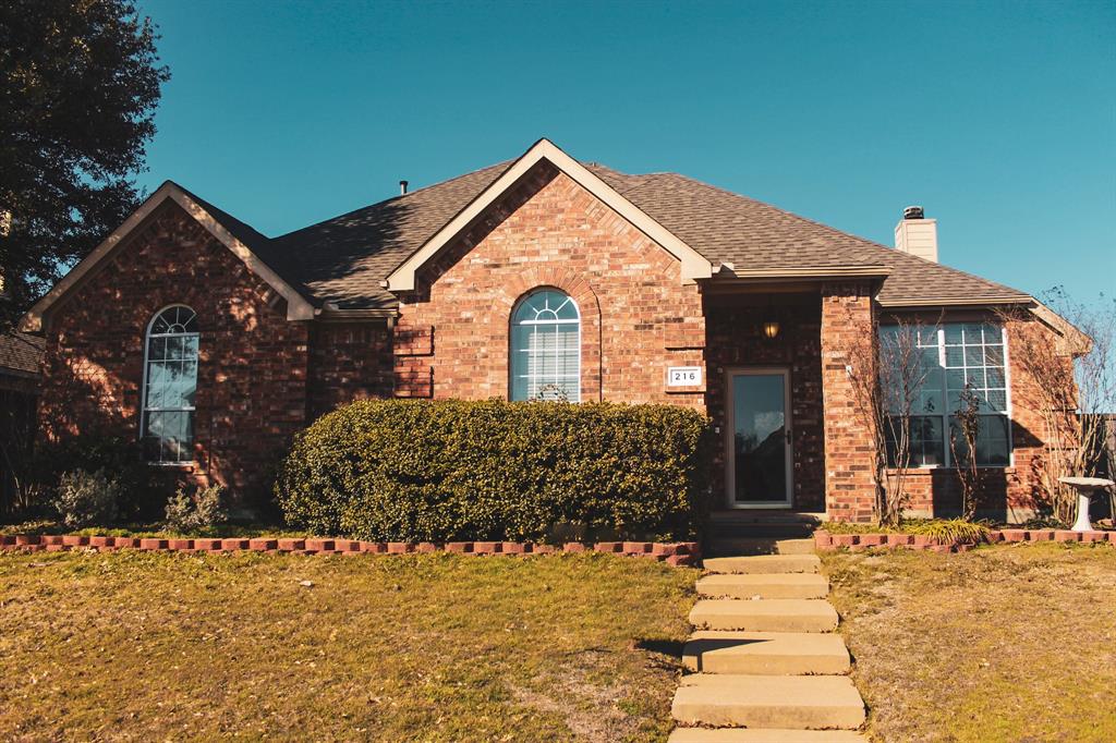 a view of a brick house with large windows