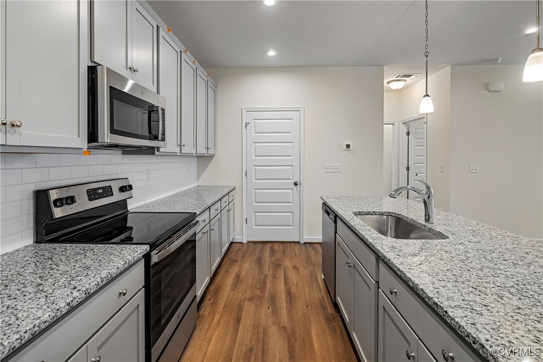 a kitchen with granite countertop stainless steel appliances and wooden cabinets