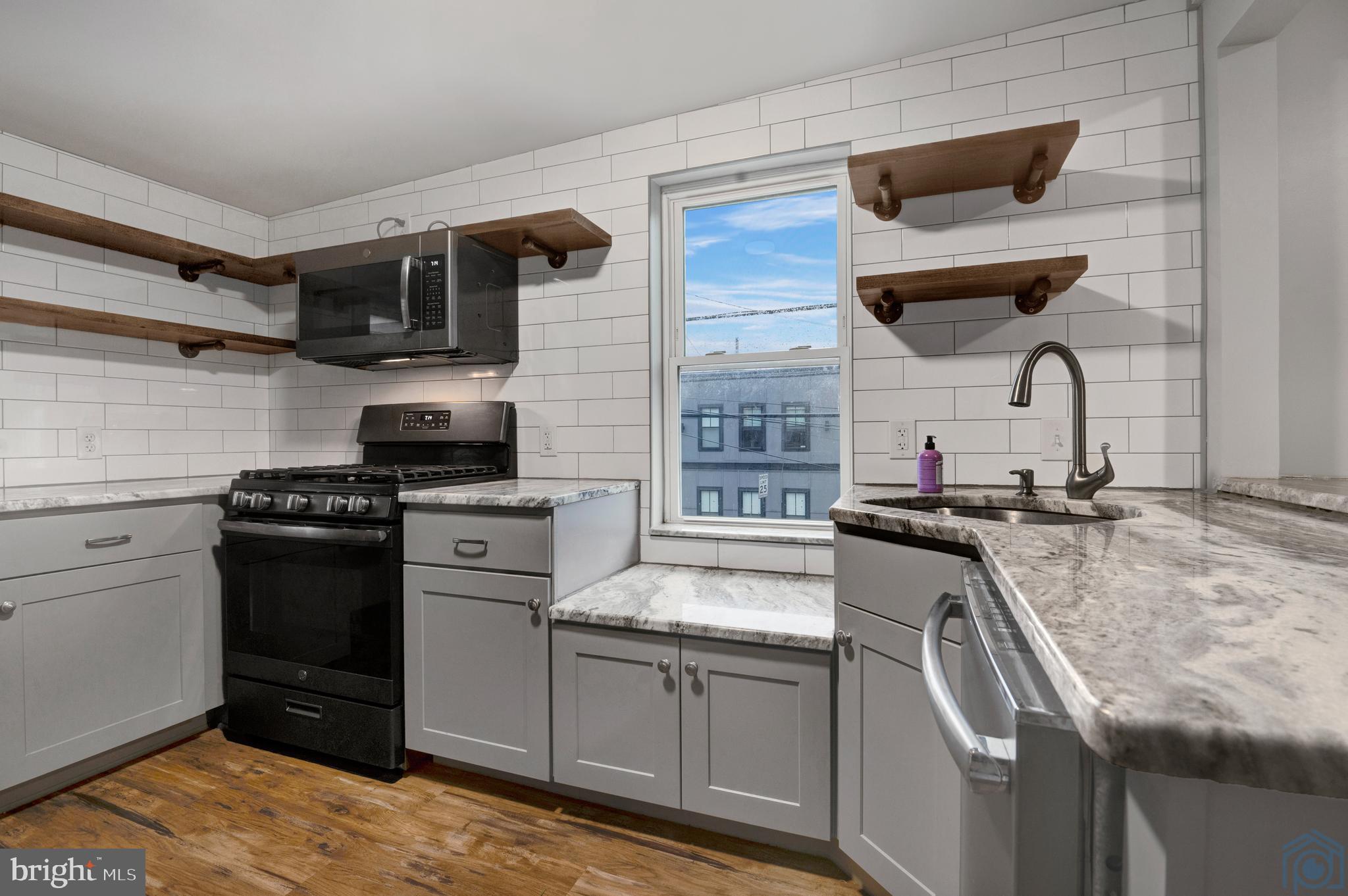 a kitchen with stainless steel appliances granite countertop a sink stove and refrigerator