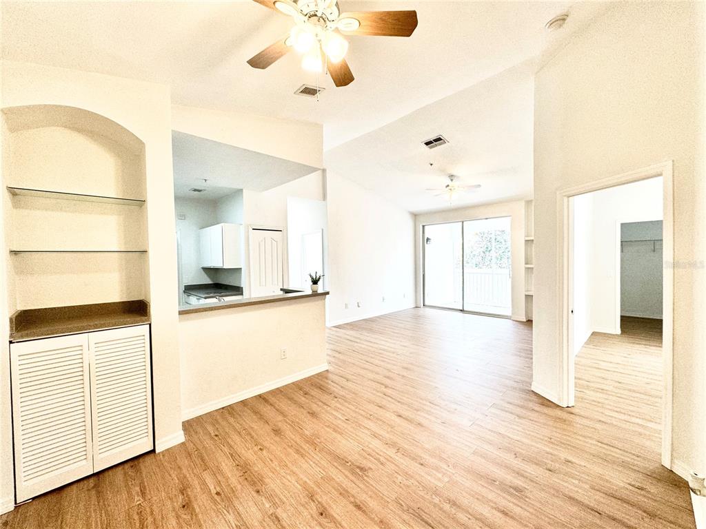 a view of a kitchen with wooden floor and a ceiling fan