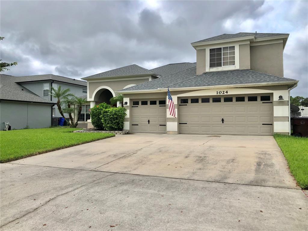 a front view of a house with a yard and garage