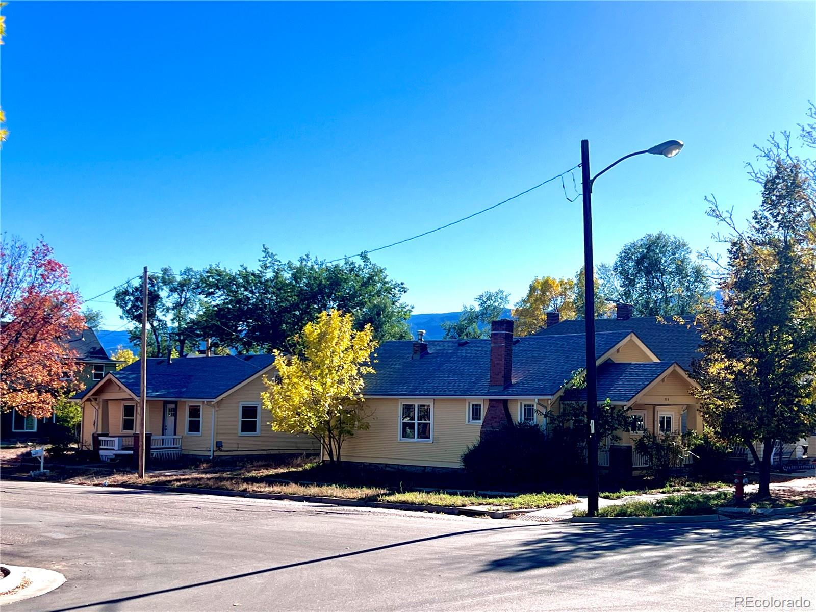 a front view of a house with a yard and tree s