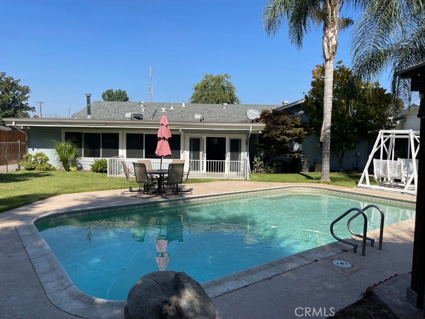 a view of house with swimming pool outdoor seating