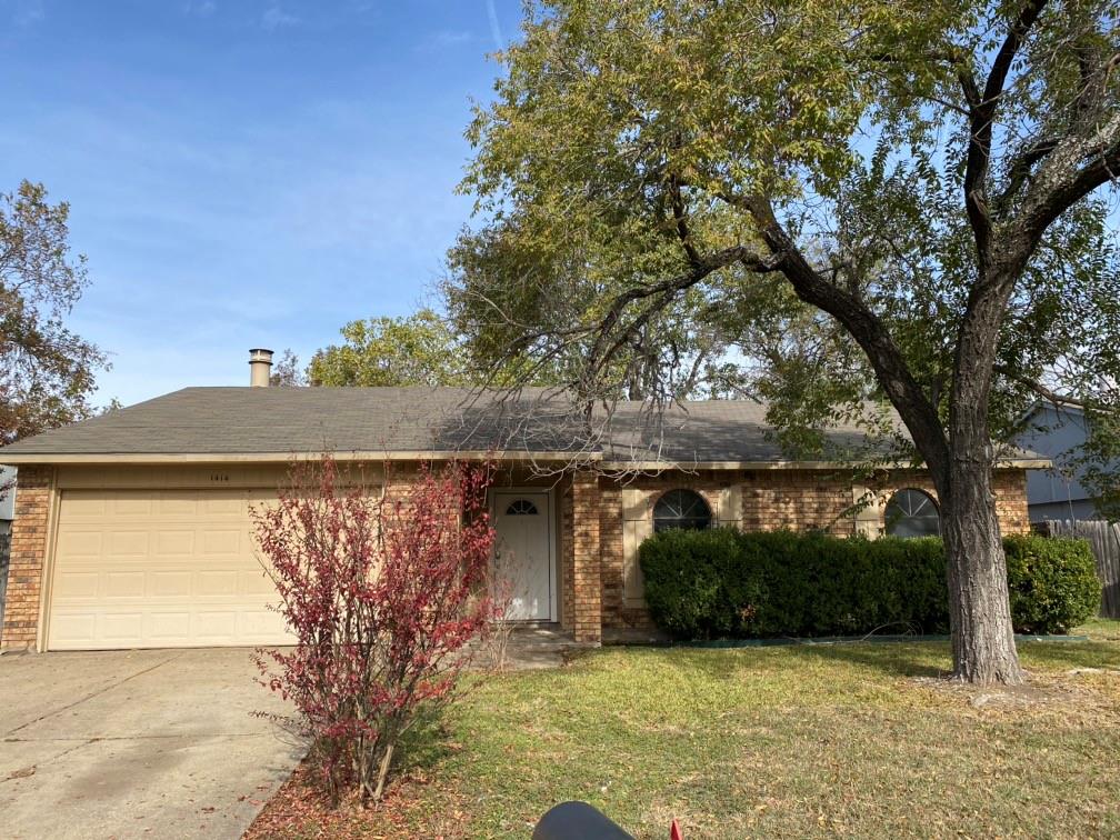 a view of a house with a large tree and a yard