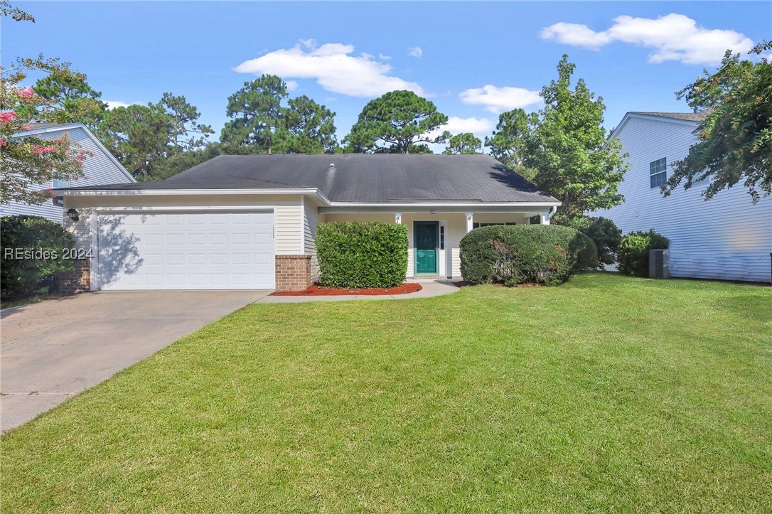 View of front facade with a garage and a front law