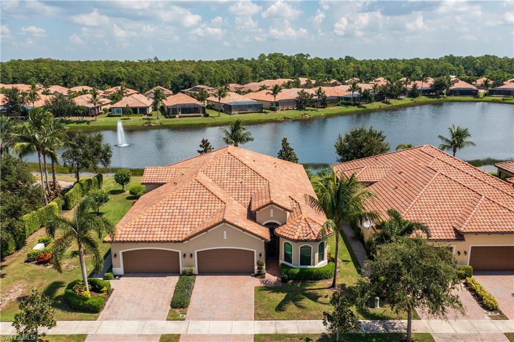 an aerial view of residential houses with outdoor space and lake view