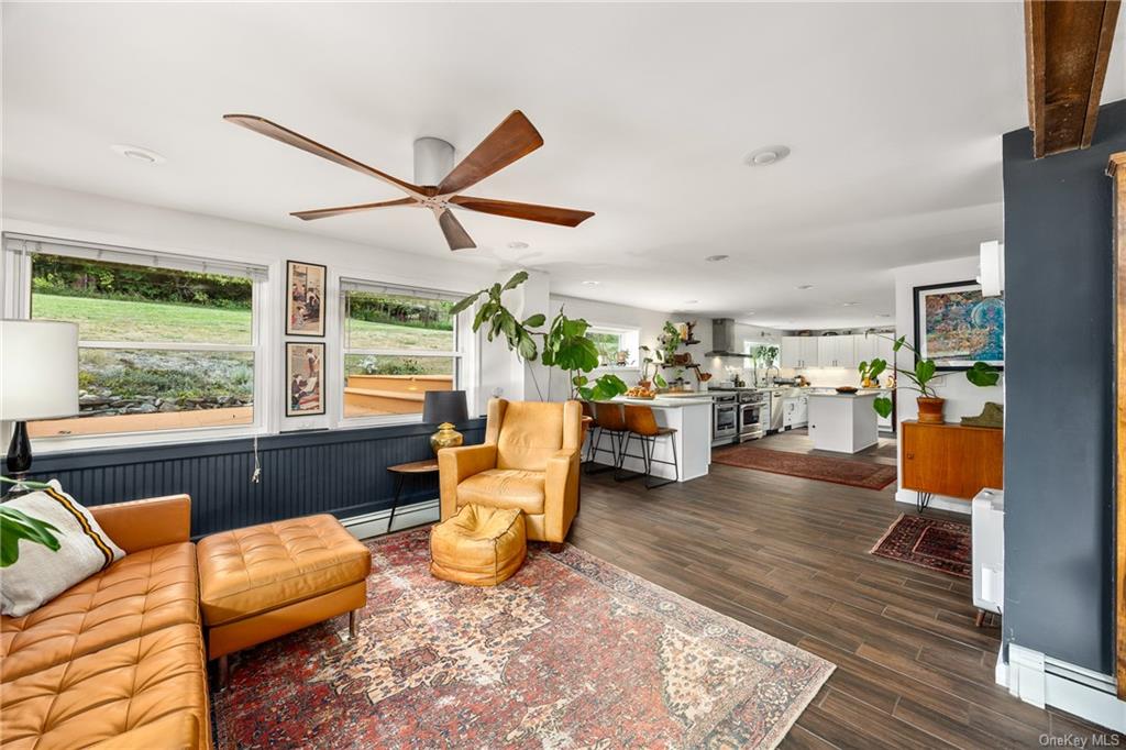 a living room with furniture kitchen view and a large window