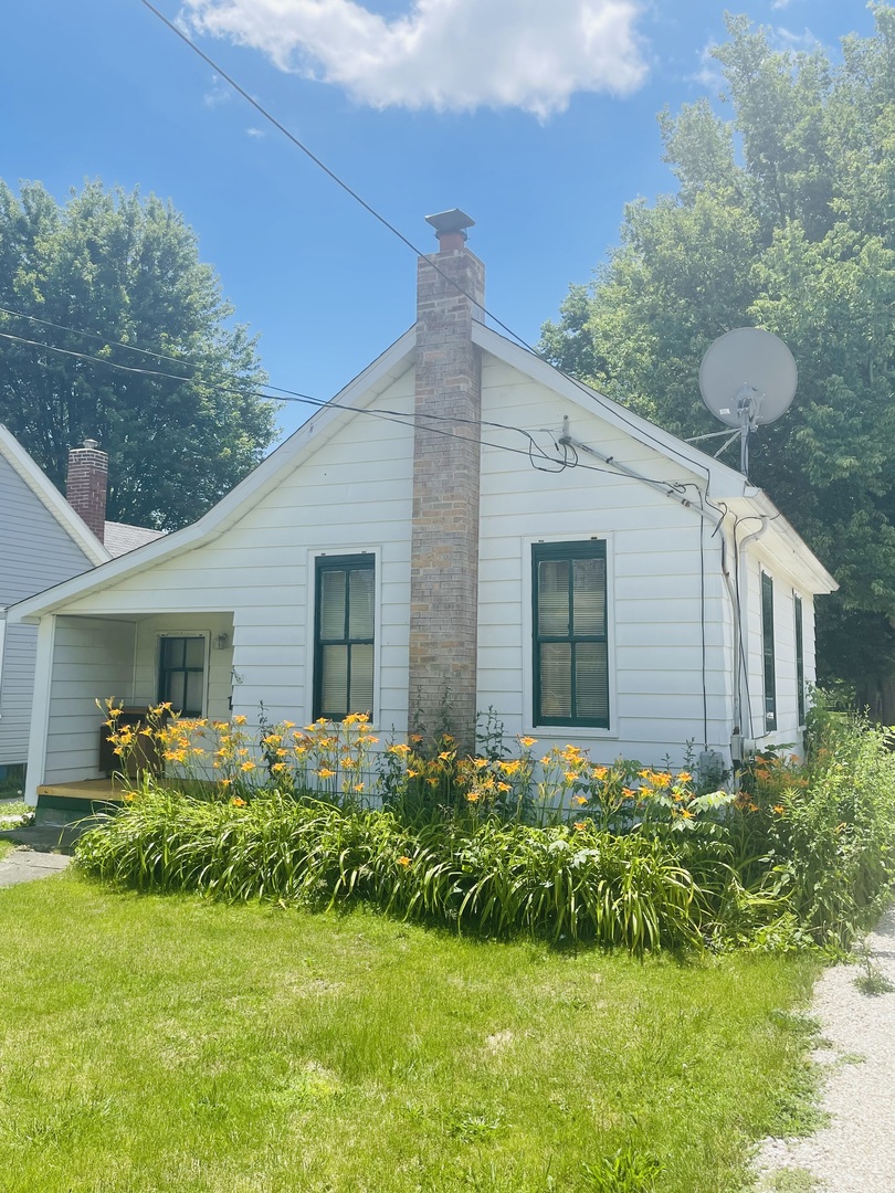 a front view of house with a yard and potted plants