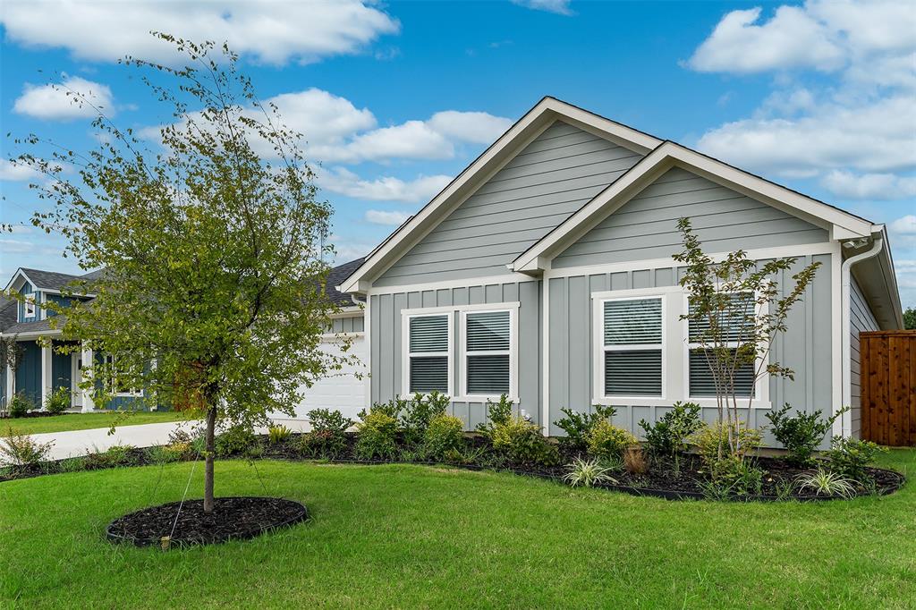 a front view of a house with a garden and yard