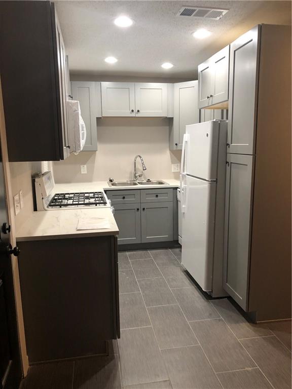 a kitchen with stainless steel appliances a refrigerator sink and microwave