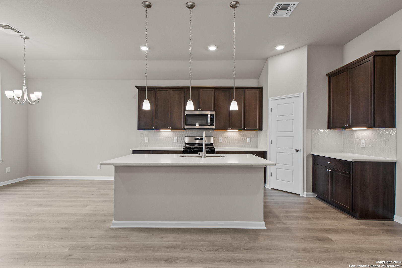 a view of kitchen with stainless steel appliances granite countertop cabinets and wooden floor