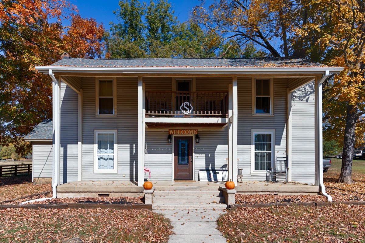 a front view of a house with a tree