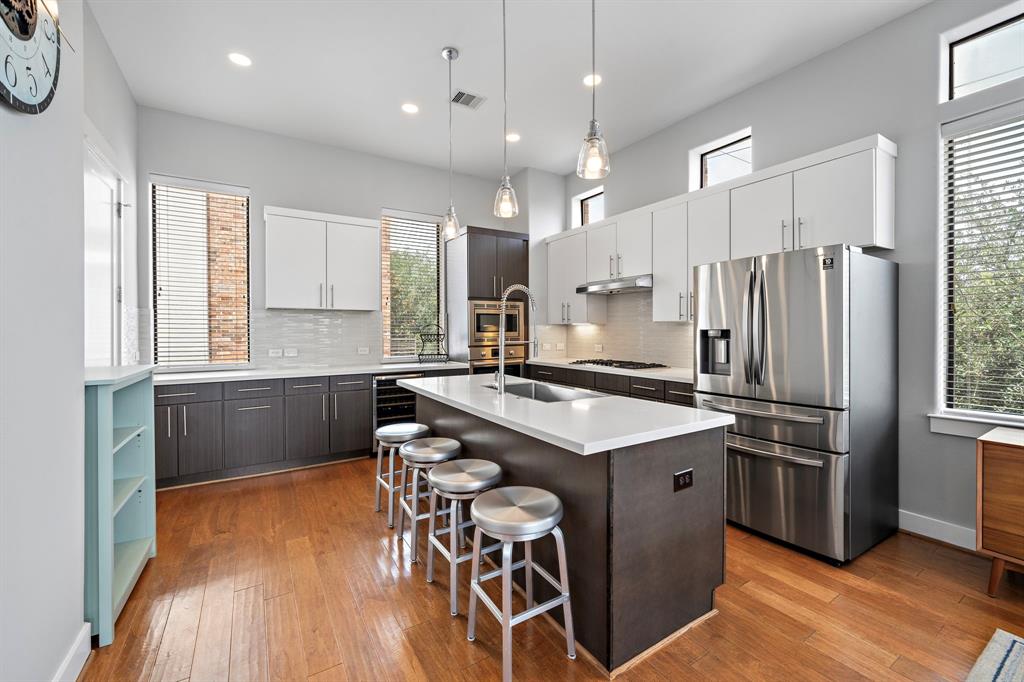 a kitchen with kitchen island a counter top space a sink stainless steel appliances and cabinets