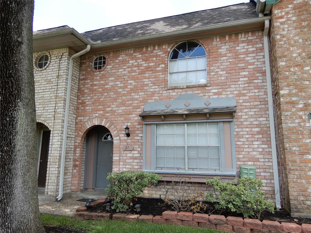 front view of a brick house with a small yard