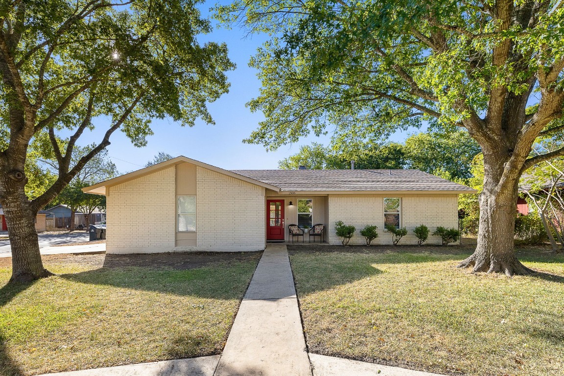 a front view of a house with a yard and trees