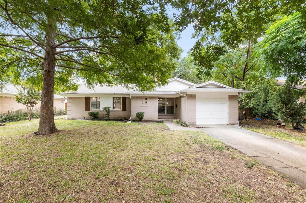 Ranch-style house with a garage and a front lawn