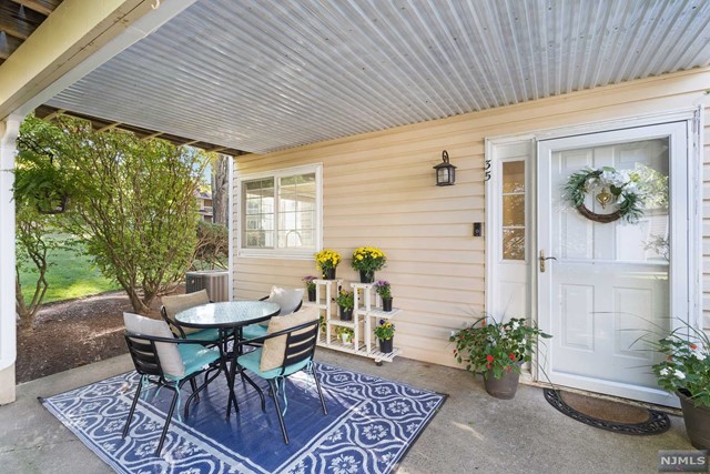 a patio with a table and chairs and potted plants