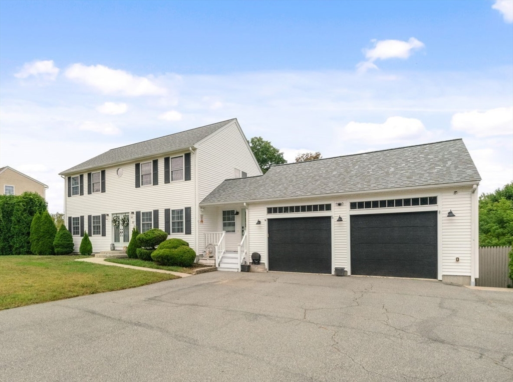 a front view of a house with a garden and garage