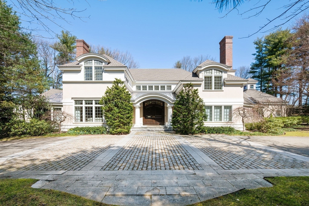 a front view of a house with yard and parking