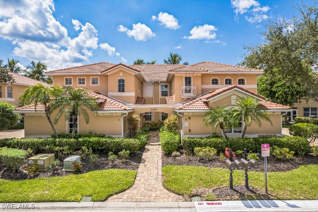 a front view of a house with a yard and potted plants