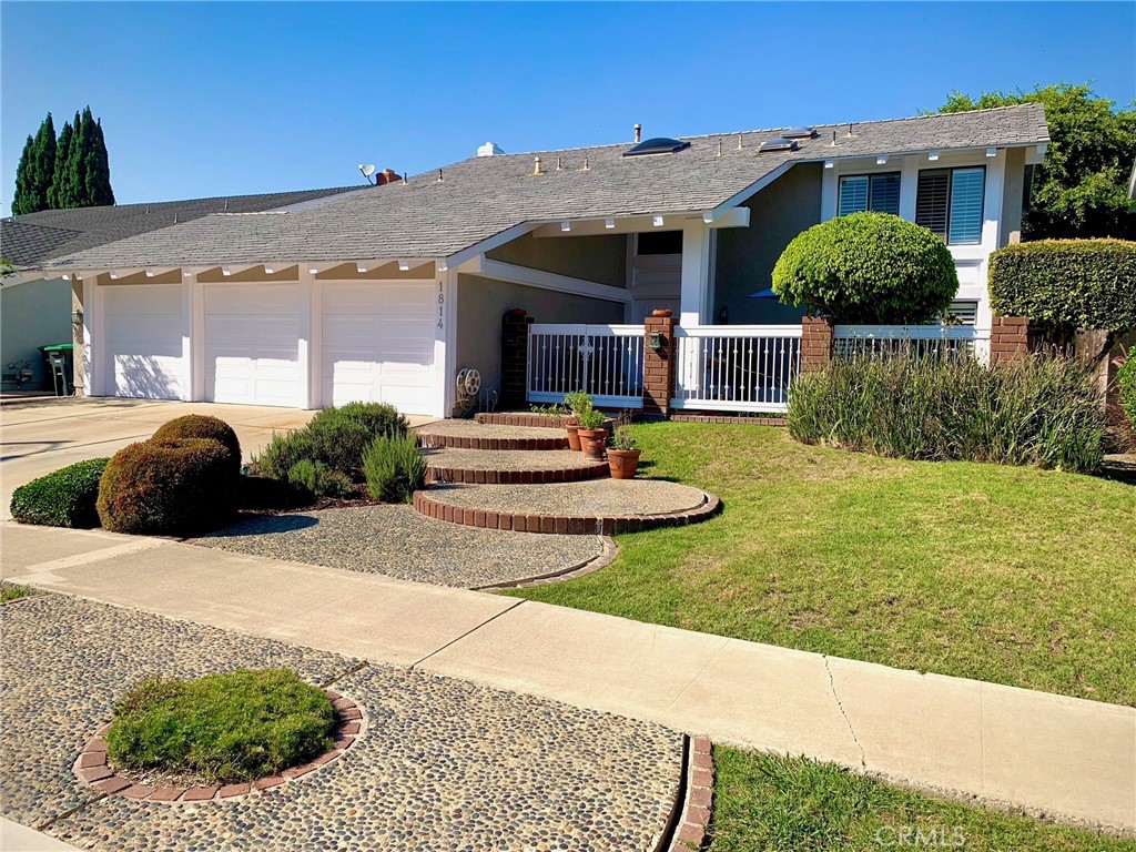 a front view of a house with garden and plants