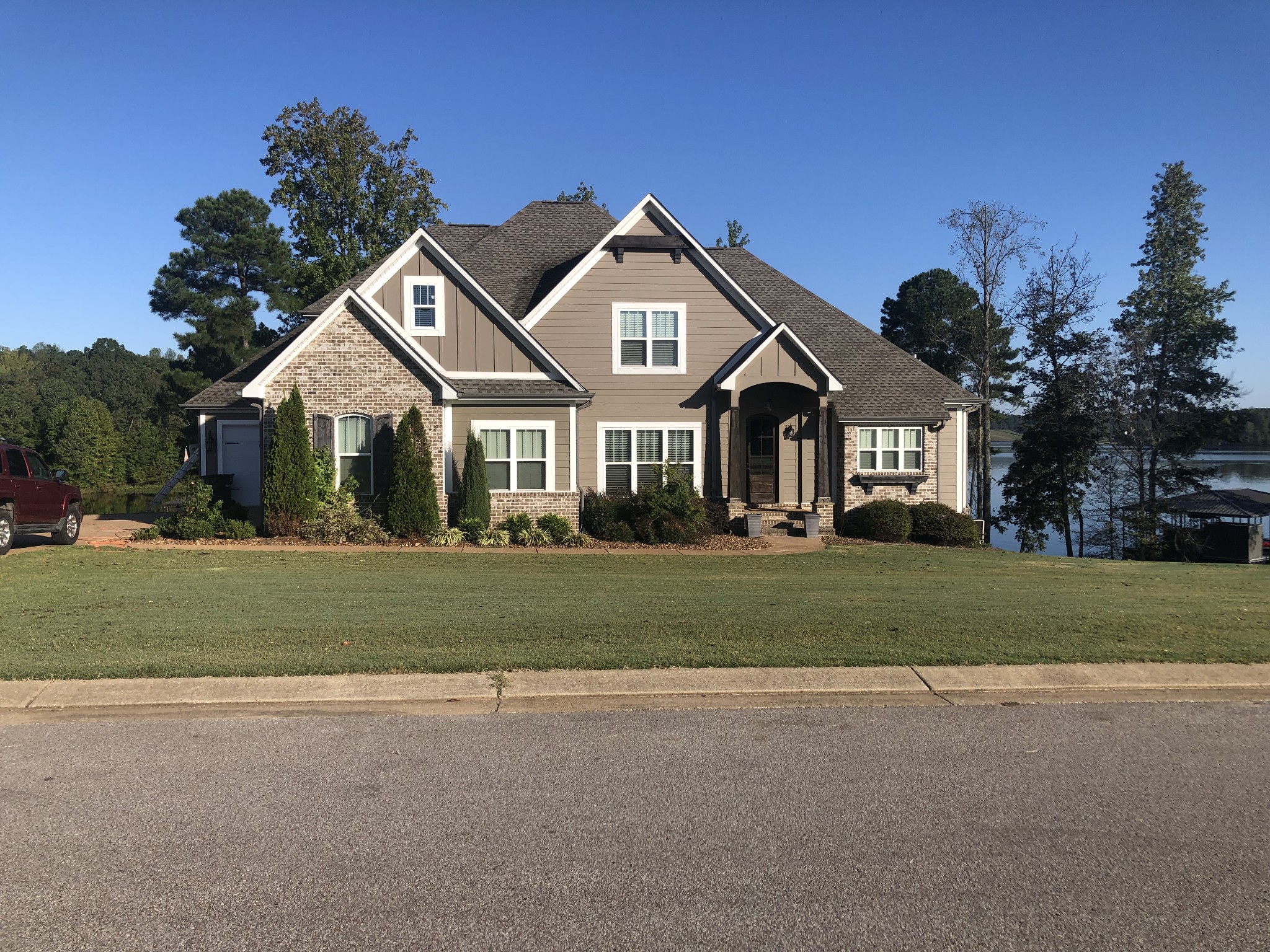 a front view of a house with a garden and trees