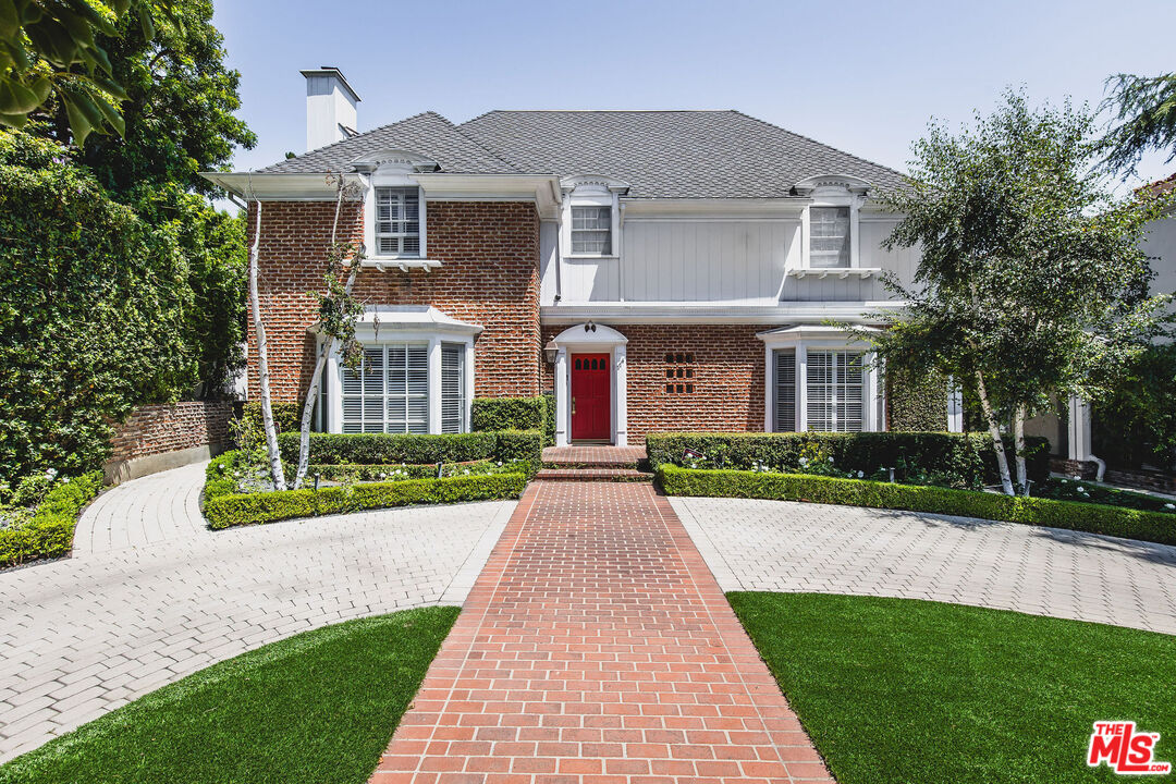 front view of a brick house with a yard