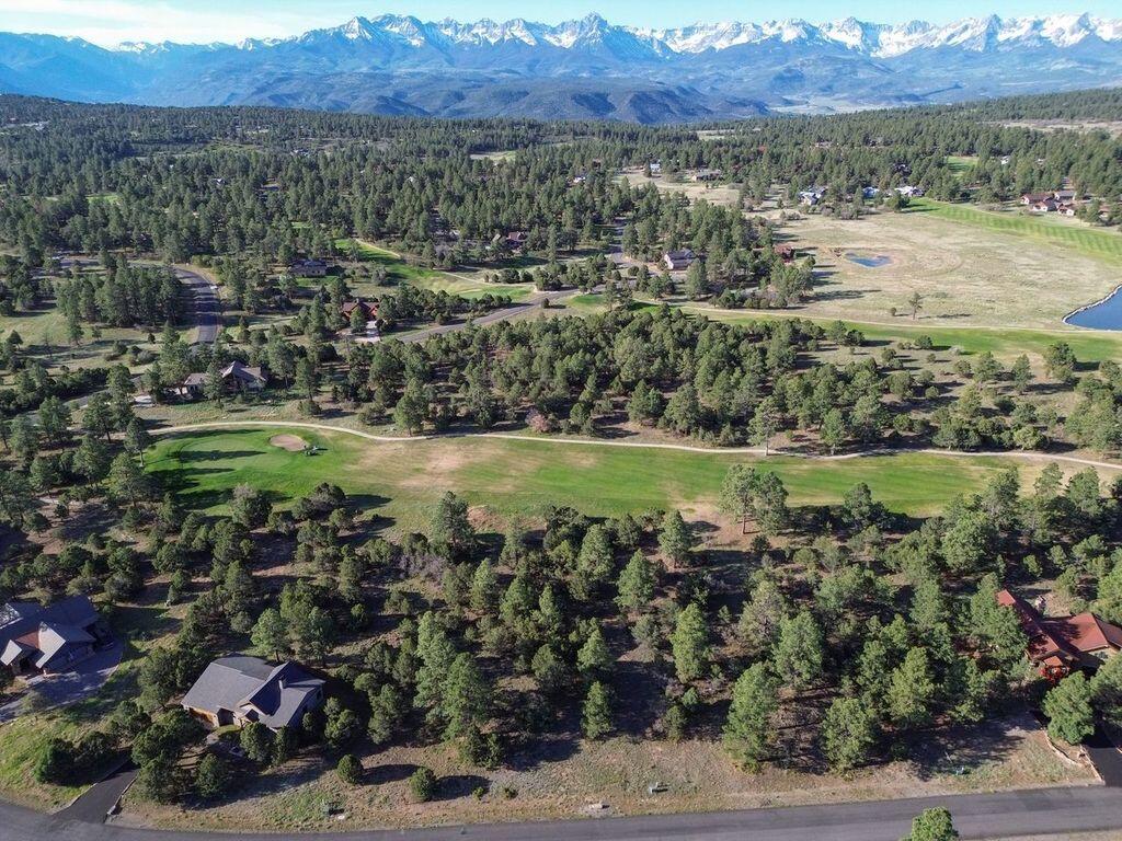 an aerial view of a houses with a yard and lake view