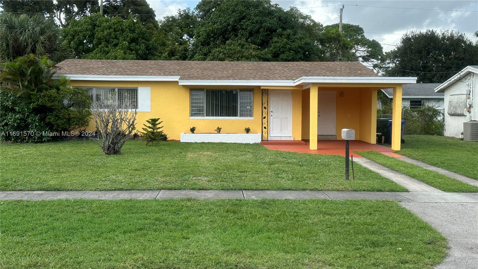 a front view of a house with a yard and trees