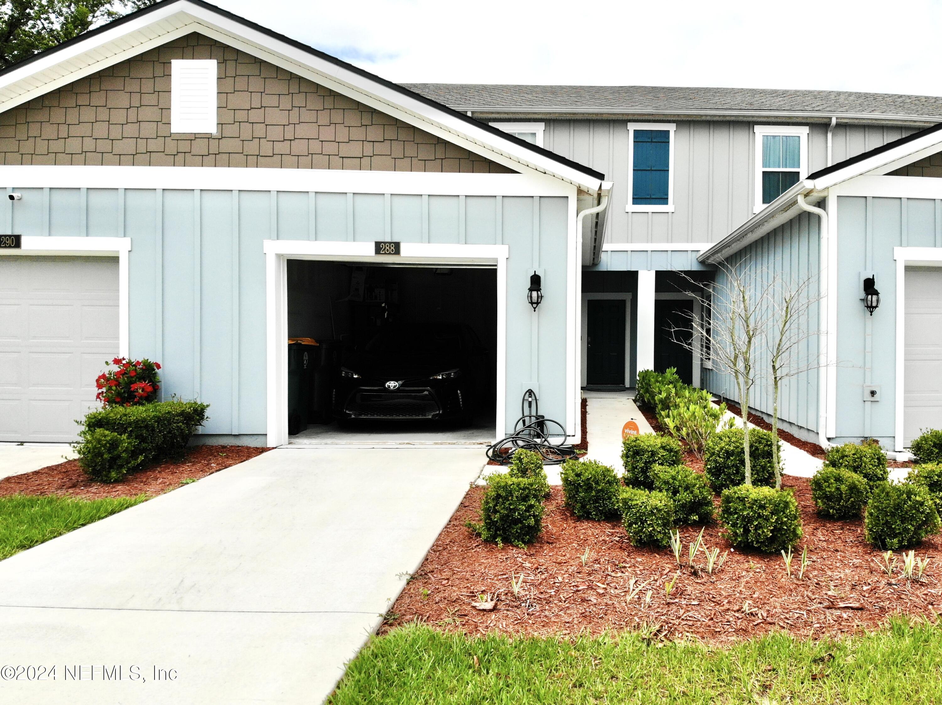 a front view of a house with a yard and a garage