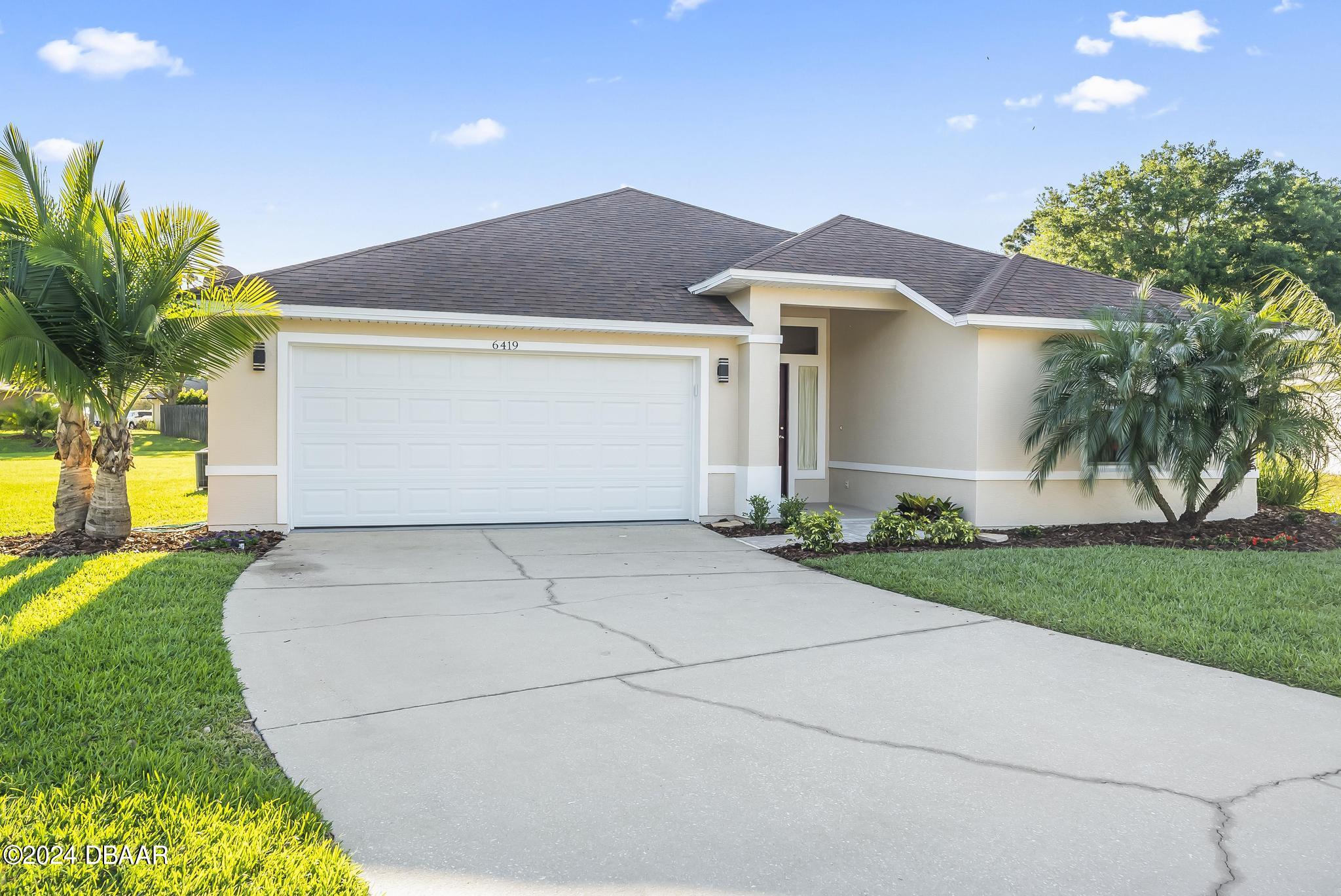 a front view of a house with a yard and garage