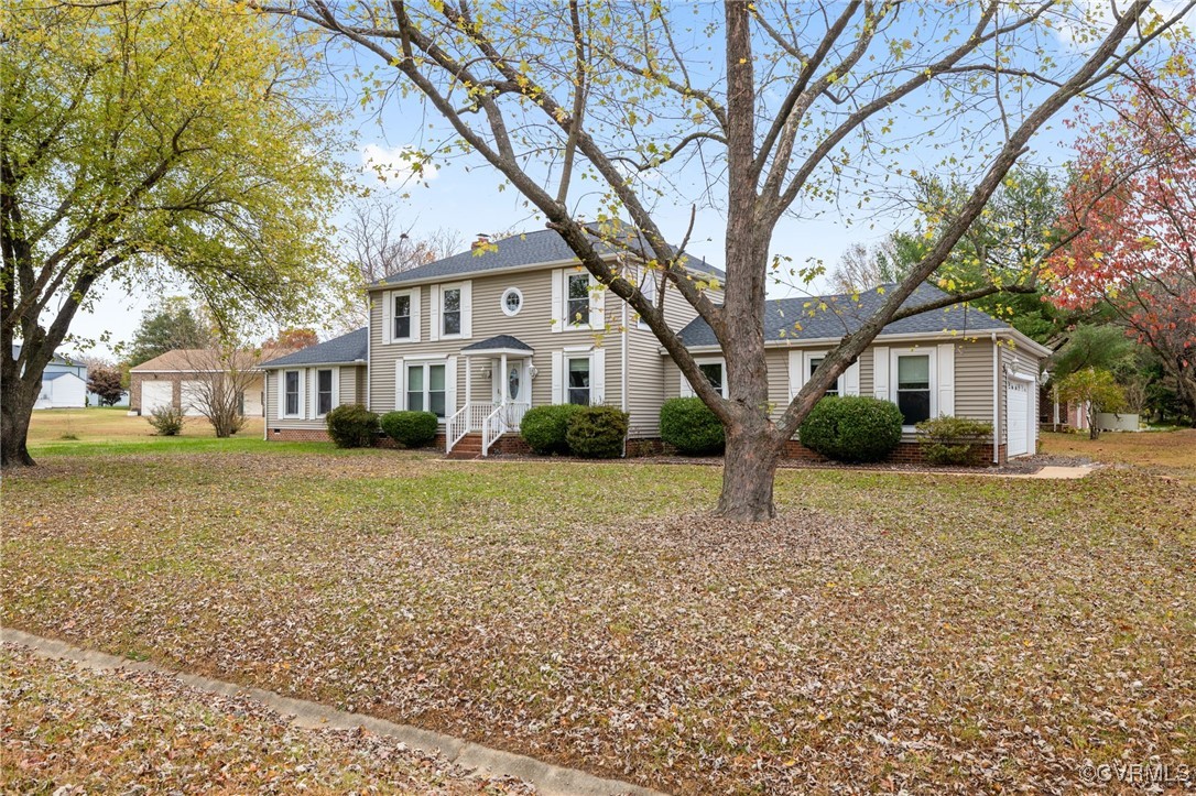 Colonial house featuring a front yard and garage