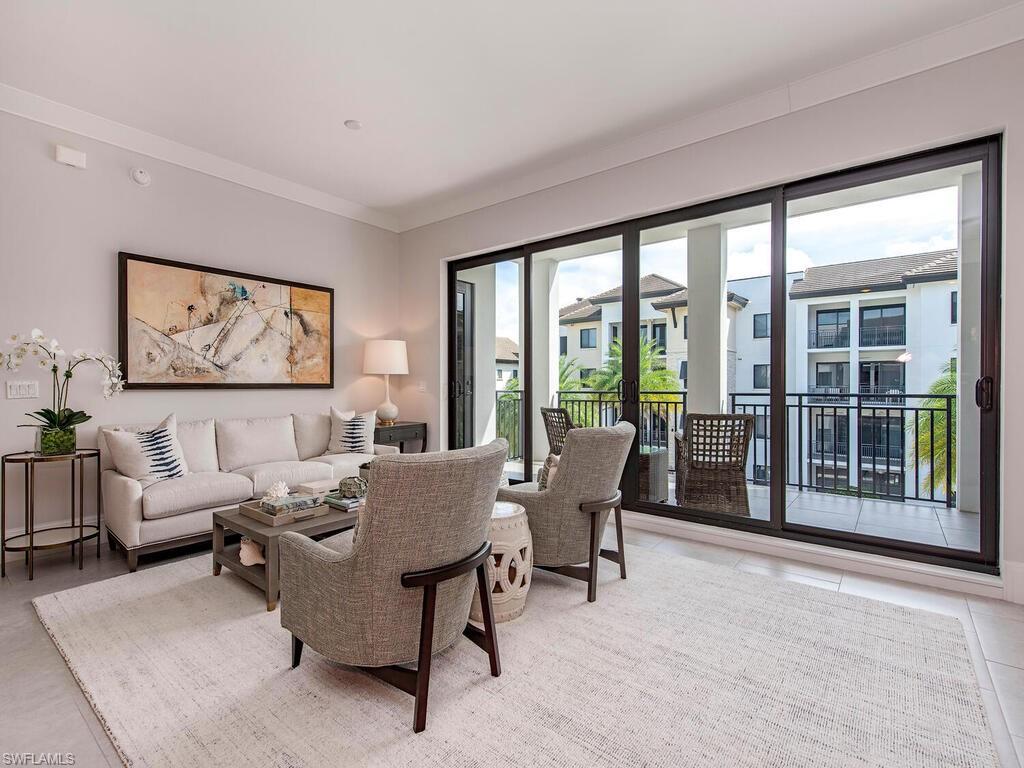 Living room featuring light tile patterned flooring and crown molding