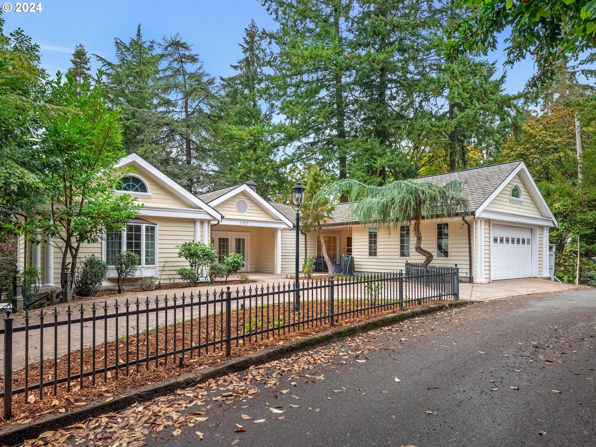 a view of a house with a small yard and wooden fence