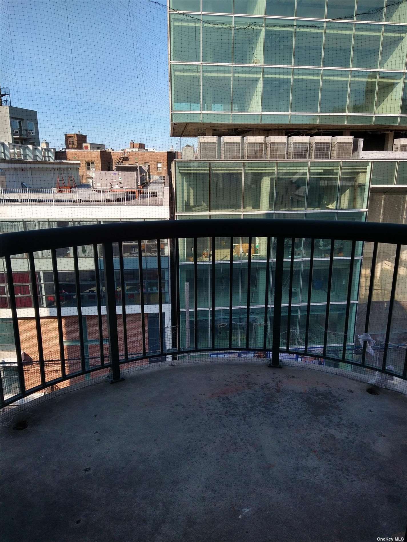 a view of a balcony with a floor to ceiling window and outdoor kitchen