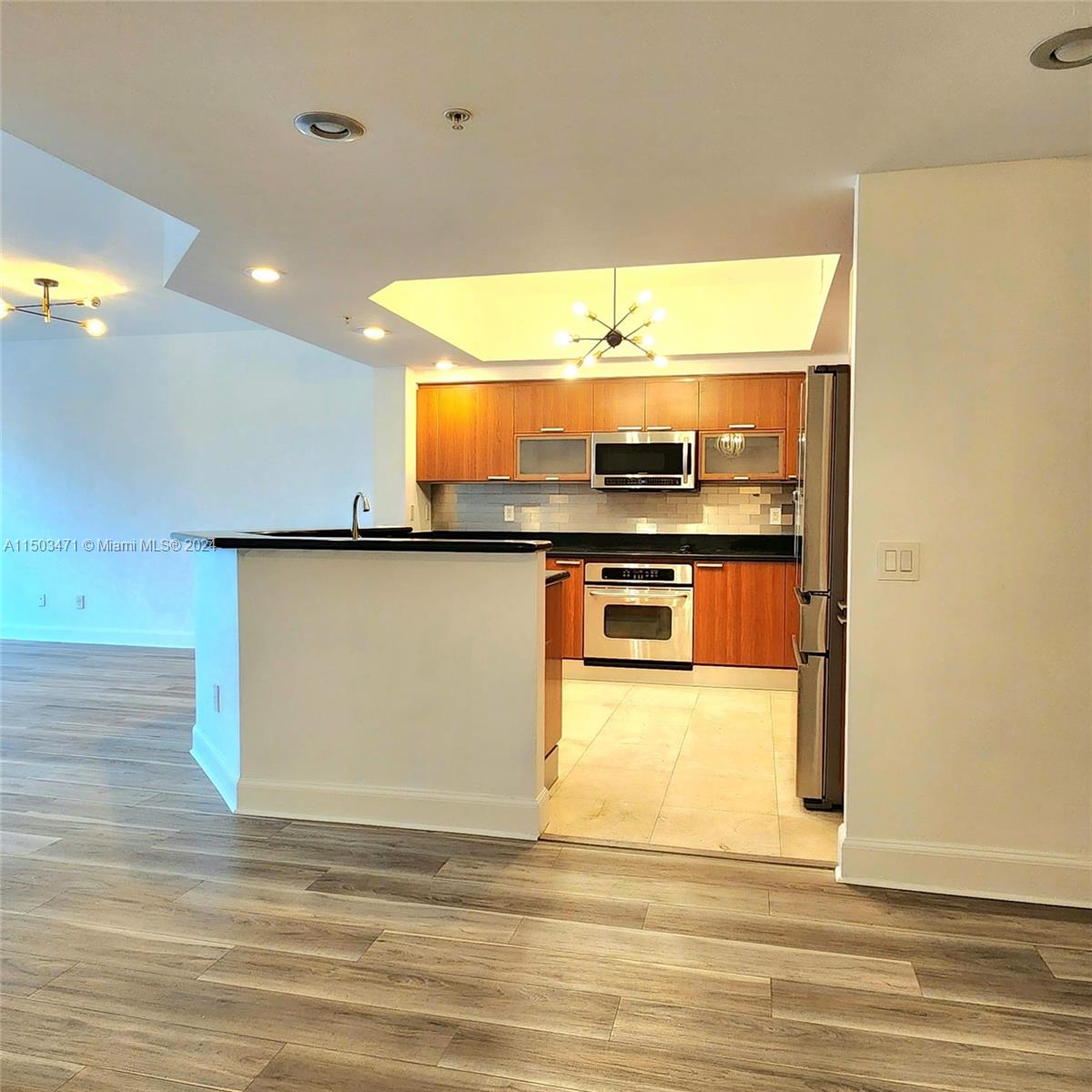 a view of kitchen with stainless steel appliances granite countertop sink and cabinets