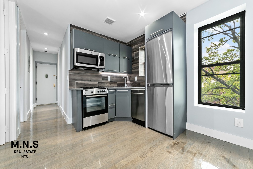 a kitchen with stainless steel appliances a refrigerator sink and microwave