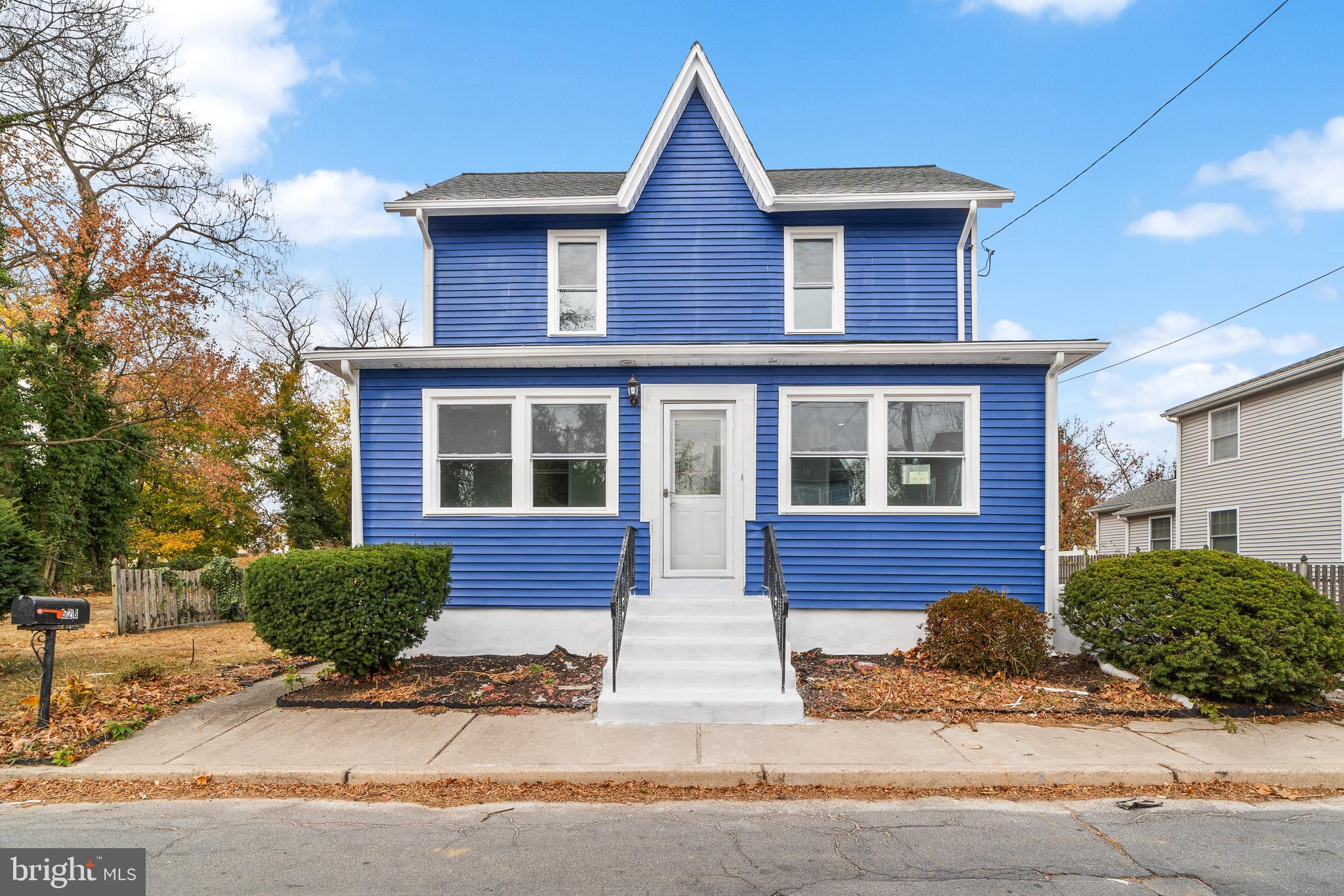 a front view of a house with yard and parking space