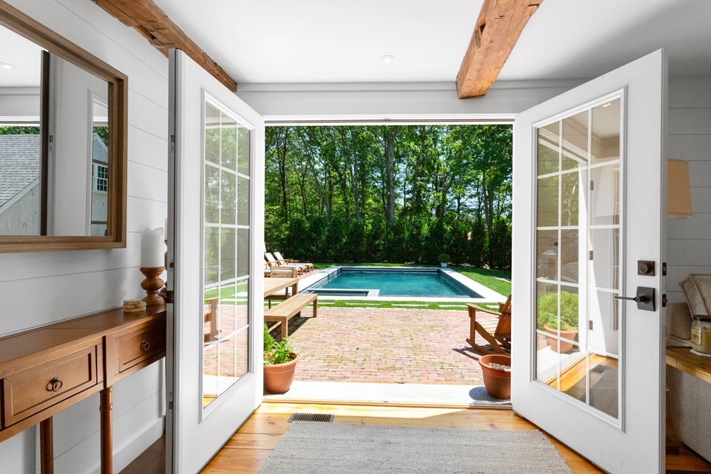 a view of a room with a large window and wooden floor