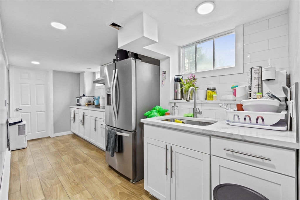 a kitchen with kitchen island white cabinets and refrigerator