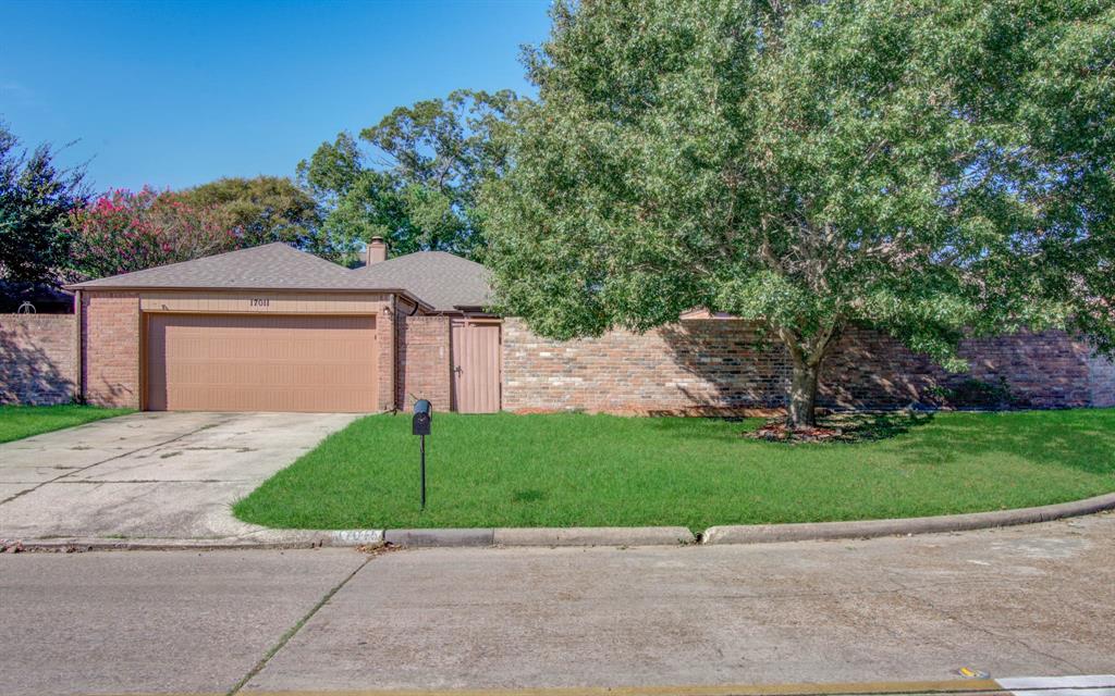 a view of a house with a small yard and a large parking space