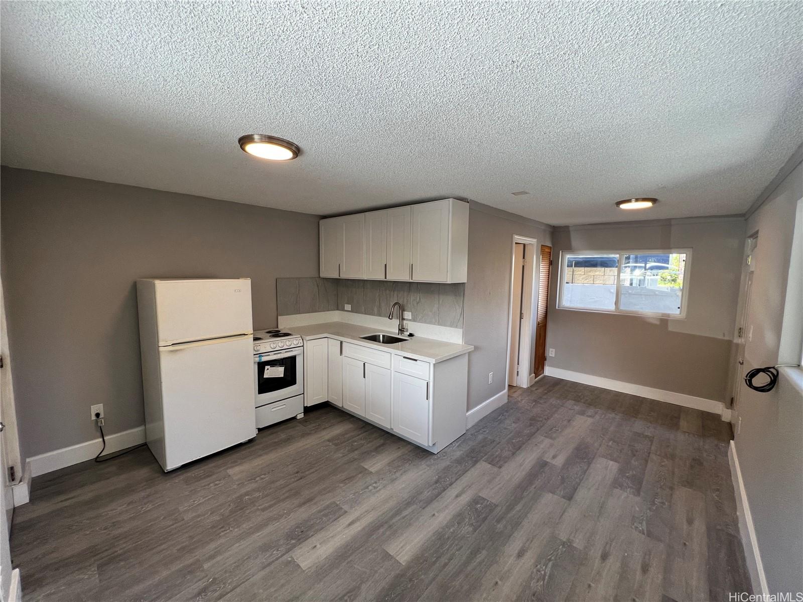 a large white kitchen with sink and refrigerator