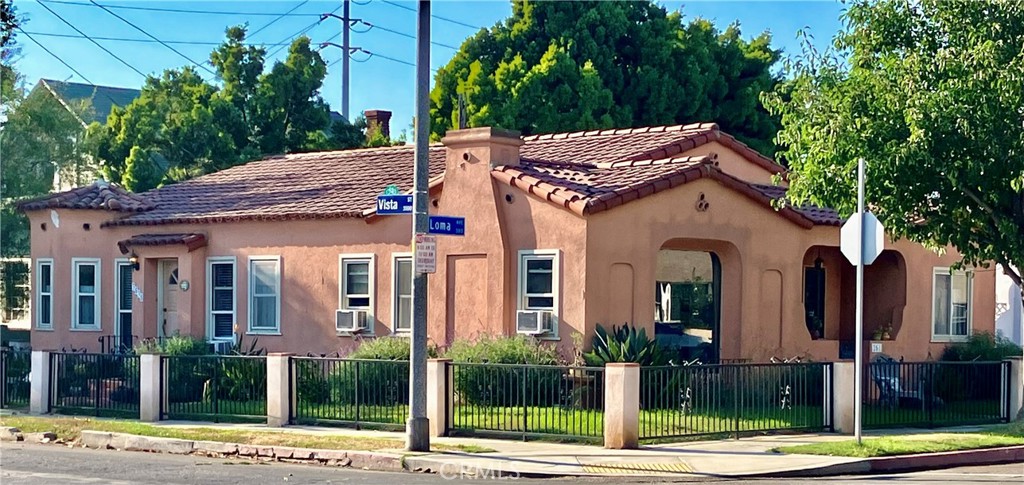 a view of a white house with large windows and palm tree