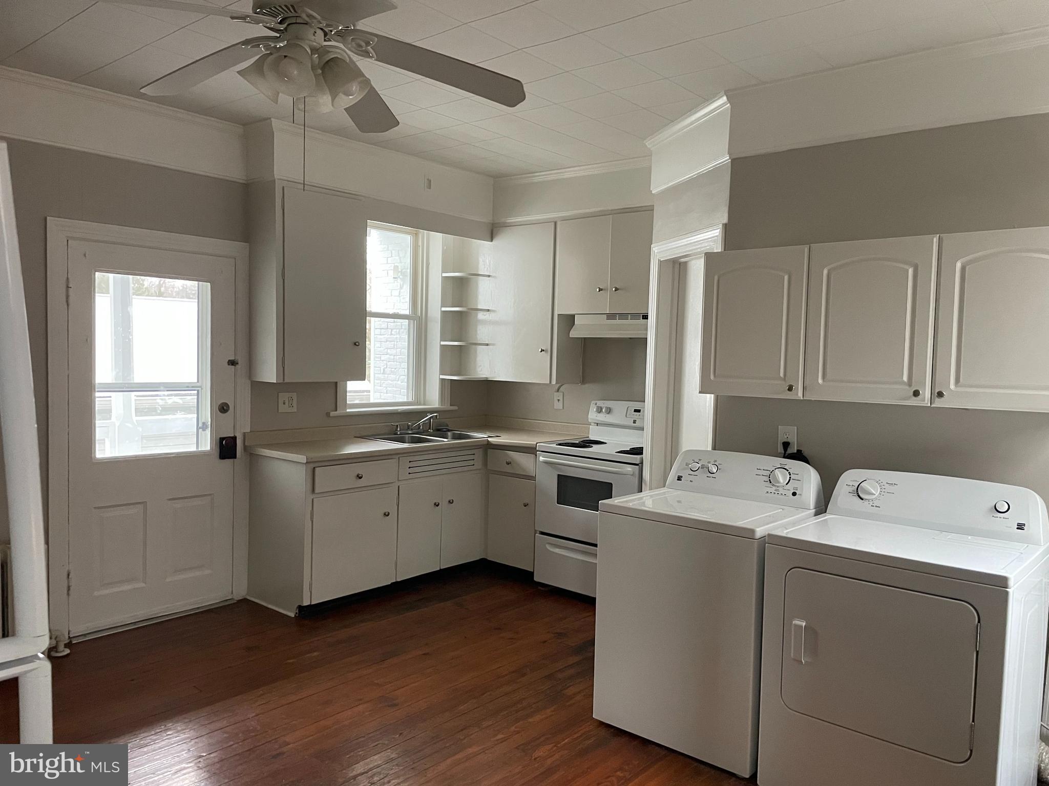 a kitchen with a sink cabinets appliances and a window