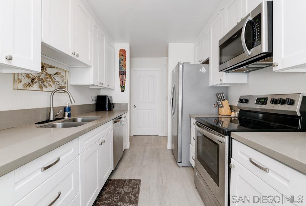 a kitchen with stainless steel appliances granite countertop a sink stove and microwave