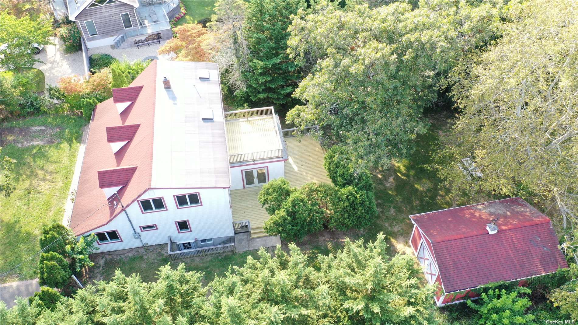 an aerial view of a house with outdoor space and trees all around