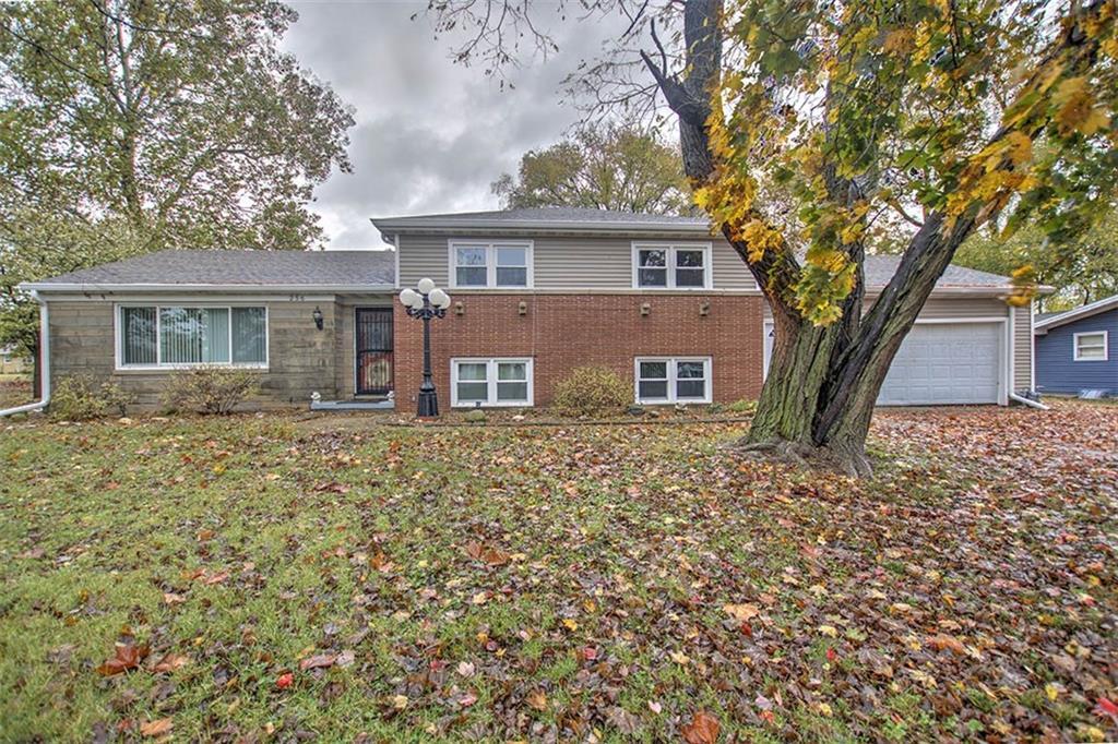 front view of a house with a large tree