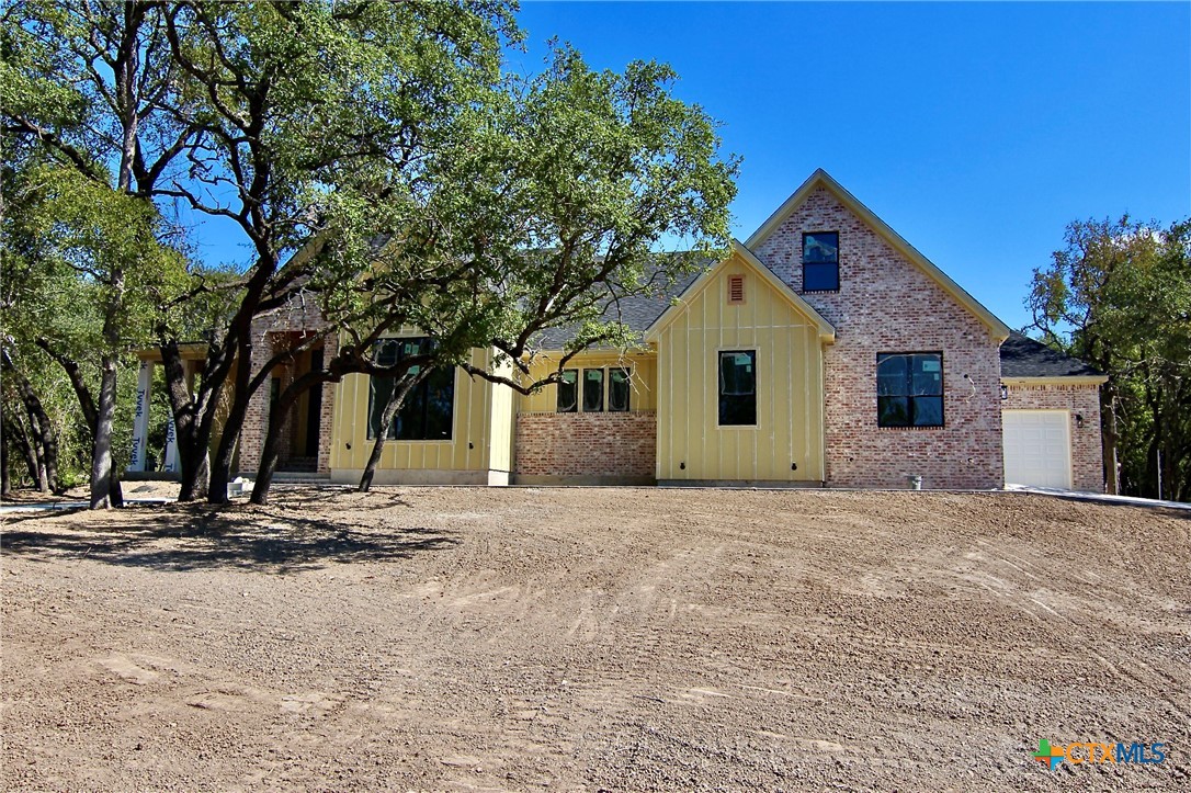 a view of a house with a yard and large tree