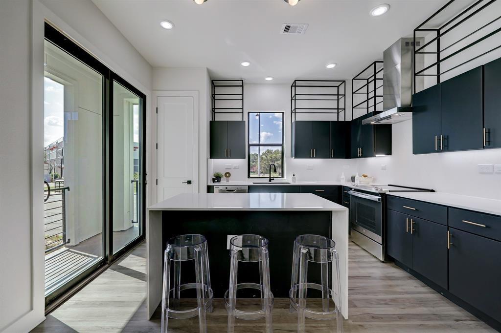 a kitchen with stainless steel appliances granite countertop a table chairs sink and cabinets