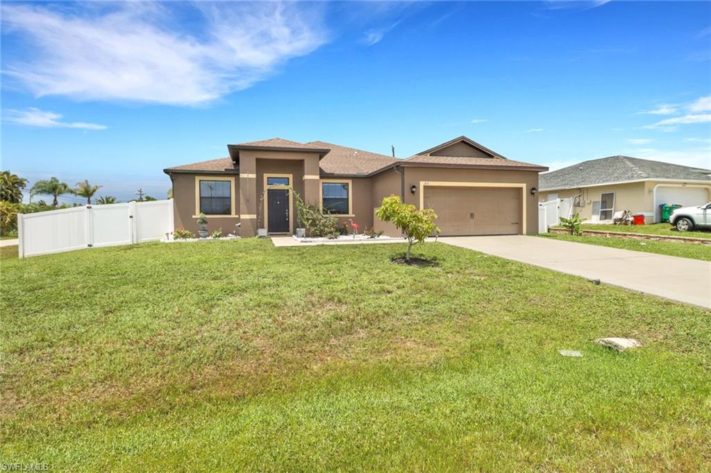 View of front of house featuring a garage and a front yard